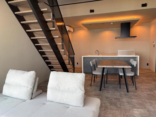 a kitchen and dining room with a table and a staircase at LIFEMENT GLANZ Okimi in Etajima