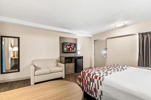 a hotel room with a bed and a chair at Red Roof Inn Washington, DC in Washington