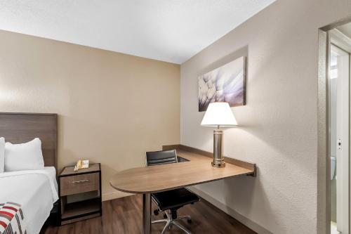 a hotel room with a bed and a desk with a lamp at Red Roof Inn Washington, DC in Washington