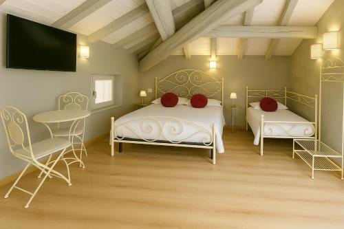 two beds in a room with a tv and chairs at Domus 44 Rooms - Porta Nuova in Verona