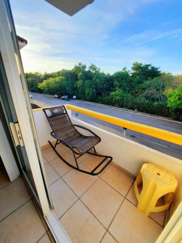 a chair sitting on a balcony looking out a window at Depa con alberca, 10 min caminando playa Ixtapa in Ixtapa