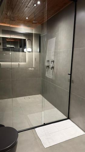 a glass shower in a bathroom with a toilet at Cabana Alecrim in Itanhandu