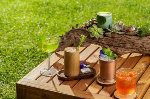 a wooden table with two glasses and a drink at JW Marriott Hotel and Suites Saigon in Ho Chi Minh City