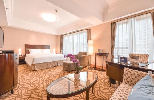 a hotel room with a bed and a table at Furama Hotel Dalian in Dalian