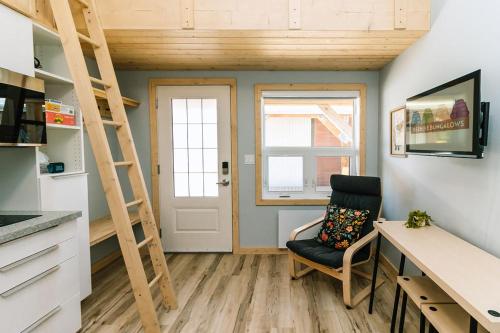 a room with a desk and a ladder and a chair at Adventure Knap Shack in Nordegg