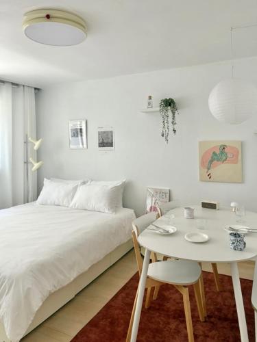 a white bedroom with a bed and a table and chairs at Aralla Stay-고척돔 15분 거리 #홍대 이태원 영등포 여의도 대중교통 30분 내 도착 #목동역 도보 15분 #목동역 차로 5분 in Seoul