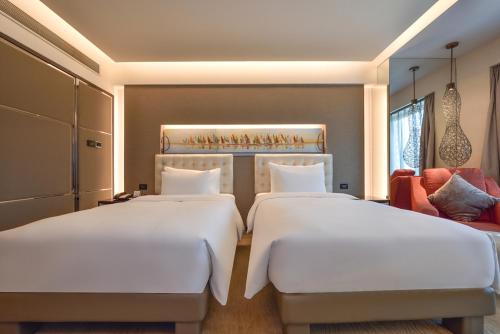 two beds in a hotel room with at Furama Hotel Dalian in Dalian