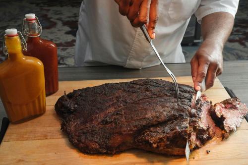 a person is cutting a steak on a cutting board at TownePlace Suites by Marriott Dallas DFW Airport North/Grapevine in Grapevine