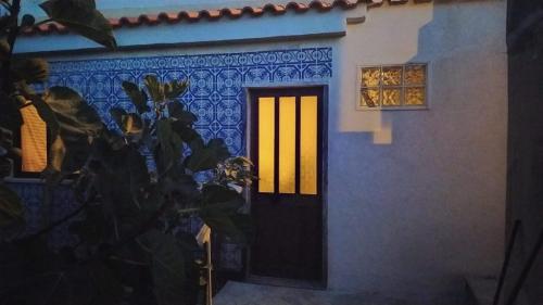 a house with a yellow door and a window at Ginjals 67 in Almargem do Bispo