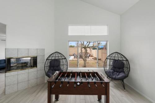 a ping pong table in a room with two chairs at City Escape in Goodyear w Pool Spring Training in Goodyear