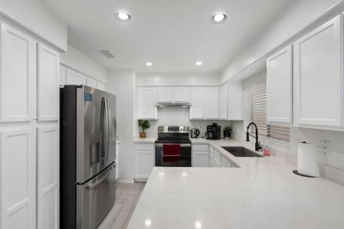 a kitchen with white cabinets and a stainless steel refrigerator at City Escape in Goodyear w Pool Spring Training in Goodyear
