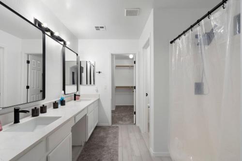 a white bathroom with two sinks and a shower at City Escape in Goodyear w Pool Spring Training in Goodyear