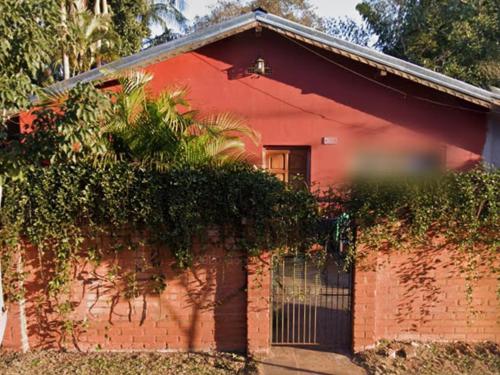 una casa de ladrillo rojo con una valla delante de ella en La casita 2 Piso compartido, en Puerto Iguazú