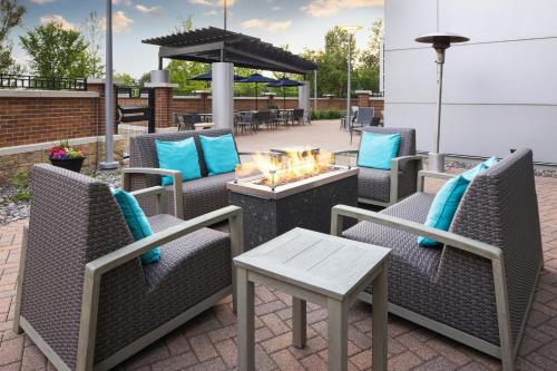 a patio with wicker chairs and a fire pit at Courtyard Minneapolis Maple Grove Arbor Lakes in Maple Grove