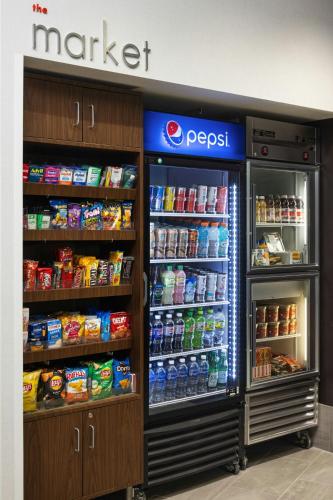 a store with a refrigerator with drinks and food at Courtyard Minneapolis Maple Grove Arbor Lakes in Maple Grove