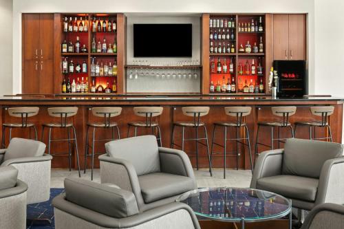 a bar in a hotel with chairs and a tv at Courtyard Minneapolis Maple Grove Arbor Lakes in Maple Grove