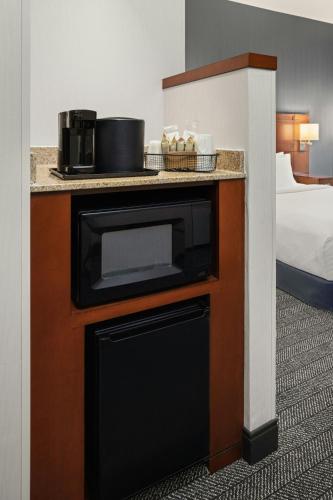 a hotel room with a microwave on a counter at Courtyard Minneapolis Maple Grove Arbor Lakes in Maple Grove