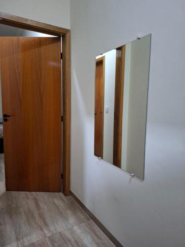 a mirror on a wall next to a door at Casa Alice e Matheus in Olímpia