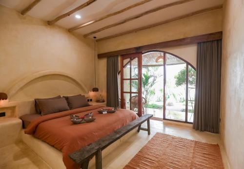 a bedroom with a bed and a large window at Amani Boutique Stay in Gili Trawangan
