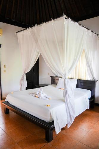 Ένα ή περισσότερα κρεβάτια σε δωμάτιο στο Badini Homestay Pemuteran Bali