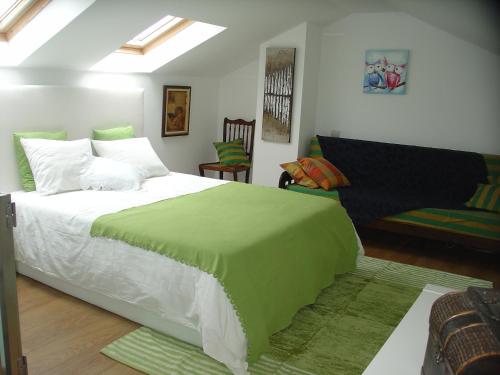 a bedroom with a bed with a green blanket on it at Casa do Terreiro in Beiral do Lima