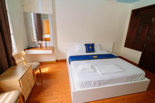 a small bedroom with a white bed and a chair at Điêu Thuyền Motel 199VTK in An Khê