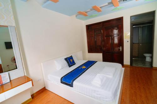 a bedroom with a white bed with a blue blanket at Điêu Thuyền Motel 199VTK in An Khê