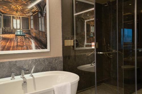 a bathroom with a tub and a glass shower at InterContinental Hotels Real Lima Miraflores by IHG in Lima