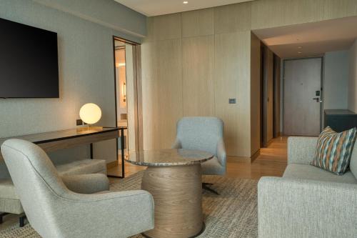 a living room with chairs and a table and a television at InterContinental Hotels Real Lima Miraflores by IHG in Lima