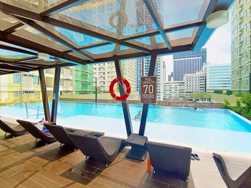 a swimming pool with chairs and a no swimming sign at 1205T2 Avida Riala IT Park 1BR Unit 400Mbps Internet in Cebu City