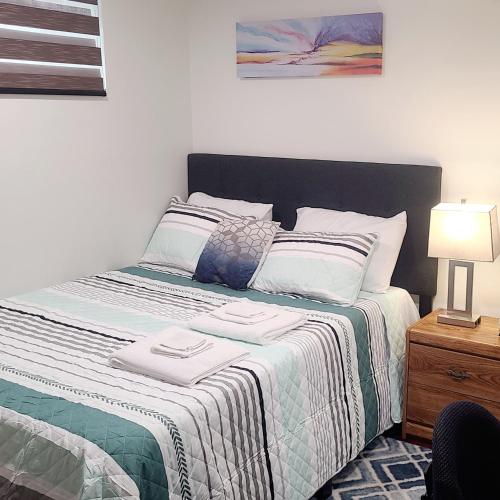 a bed with two towels on it in a bedroom at Two luxury bedrooms in the basement in Winnipeg