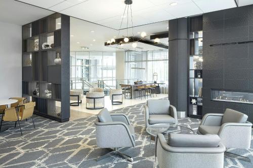 a lobby with chairs and a table and a dining room at Courtyard by Marriott Buffalo Downtown/Canalside in Buffalo