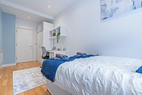 a white bedroom with a bed and a desk at Spacious Central Leeds Flat - Sleeps 8 - View City Centre in Central Station