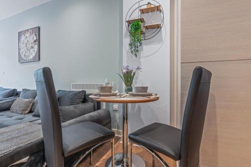 a table and chairs in a living room with a couch at Spacious Central Leeds Flat - Sleeps 8 - View City Centre in Central Station