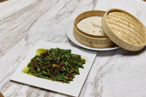 a plate of food with green vegetables on a table at Midori Clark Hotel and Casino in Clark