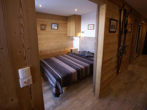 a bedroom with a bed in a room with wooden walls at Appartement entièrement rénové, proche pistes, parking privé, Pra-Loup - FR-1-165A-200 in Uvernet-Fours