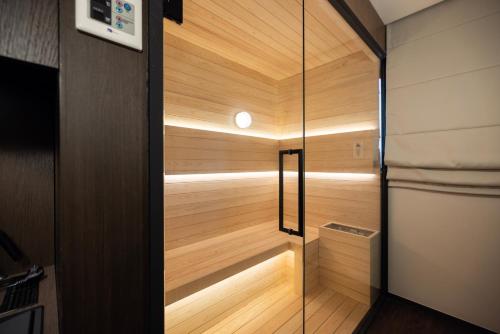 a sauna with wood paneling and a glass door at Aank Ryokan Hotel Suwon in Suwon