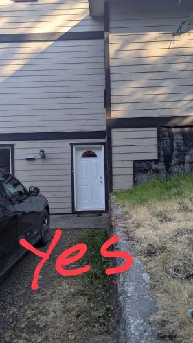 a house with a car parked in front of a door at Davidson Star in Sooke