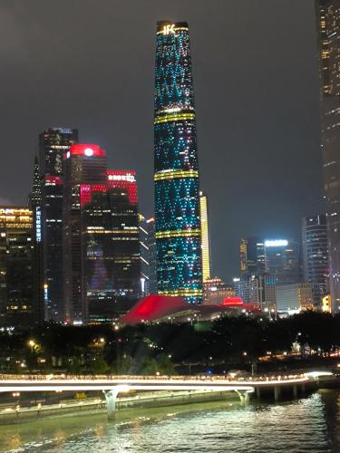 a tall skyscraper with lights in a city at night at HOTEL VIP 46 SSQS in Bagua Grande