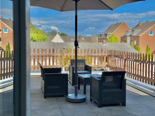 a table and chairs with an umbrella on a balcony at 6 Min zum Hbf - Ideal für Paare, Solo-Reisende oder Business-Reisende in Mönchengladbach