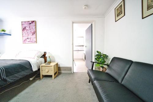 a living room with a couch and a bed at Campbell Green Door Entry Suite in Campbell