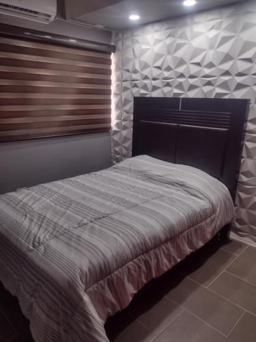 a bedroom with a bed in a room with a window at Céntrico y accesible in Ciudad Juárez