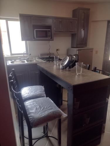 a kitchen with a island with a counter top at Céntrico y accesible in Ciudad Juárez