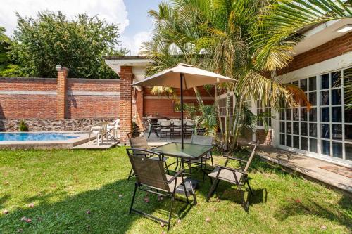 a table and chairs with an umbrella in the yard at Casa Gume in Yautepec