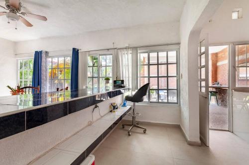 an office with a desk and a chair in a room with windows at Casa Gume in Yautepec