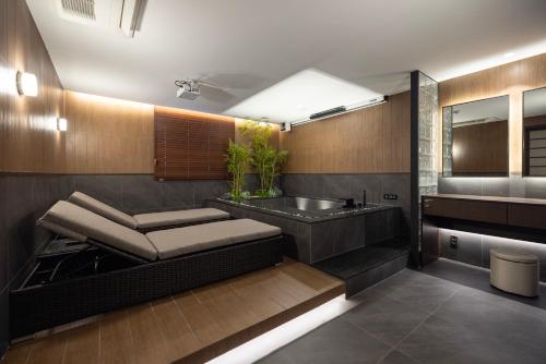 a bathroom with a sink and a bath tub at Aank Ryokan Hotel Suwon in Suwon