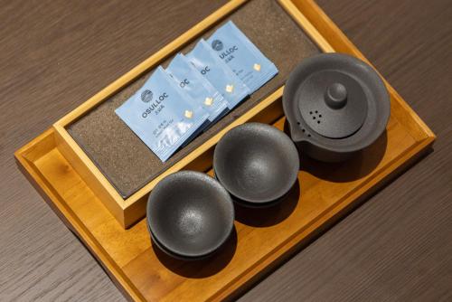 a wooden tray with four differentiatesiatesiatesiatesiatesiatesktop at Aank Ryokan Hotel Suwon in Suwon