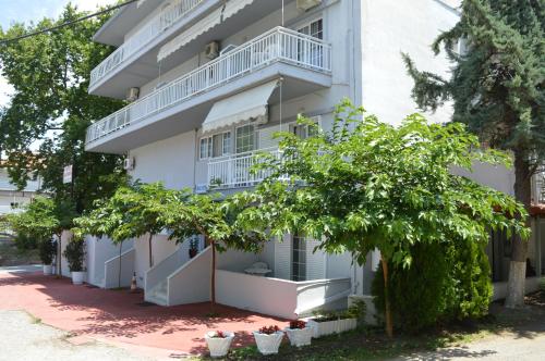 an apartment building with balconies and trees at Galanis Studios and Apartments in Platamonas
