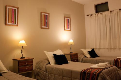 a hotel room with two beds and two lamps at Portal de La Cumbre in La Cumbre