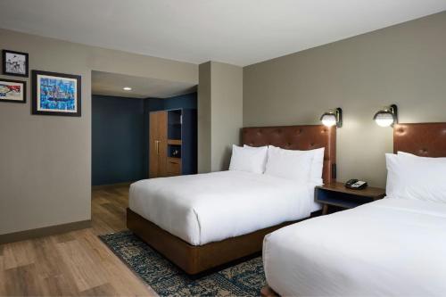 a hotel room with two beds with white sheets at Four Points by Sheraton Englewood Centennial Airport in Englewood